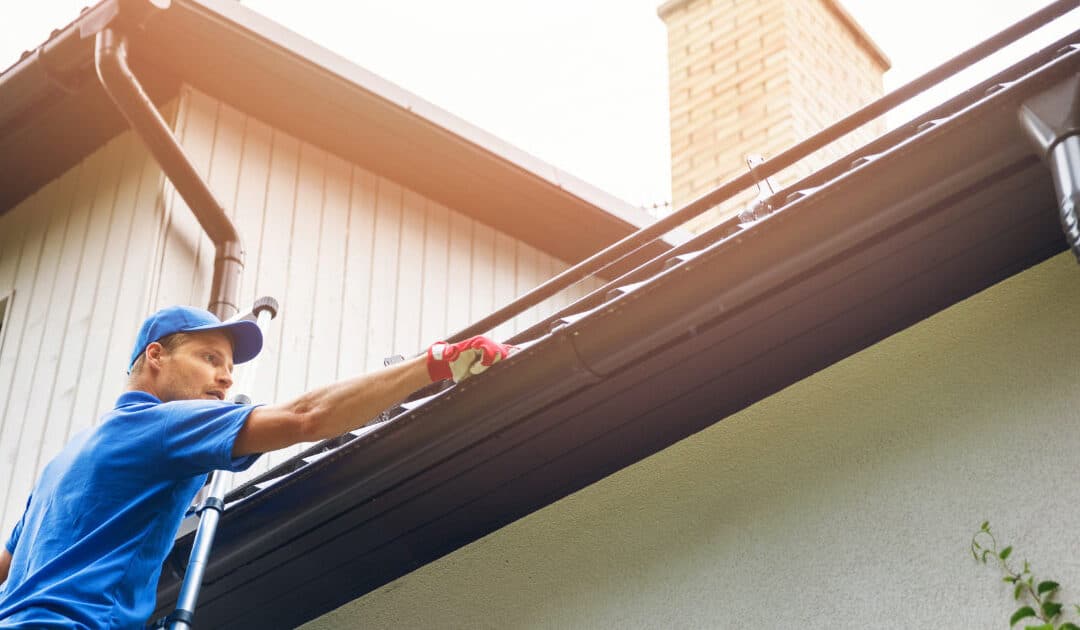 Man Working on Home's Gutters