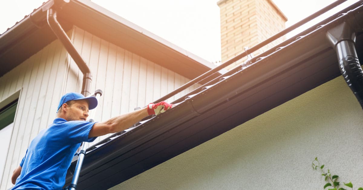 Man Working on Home's Gutters