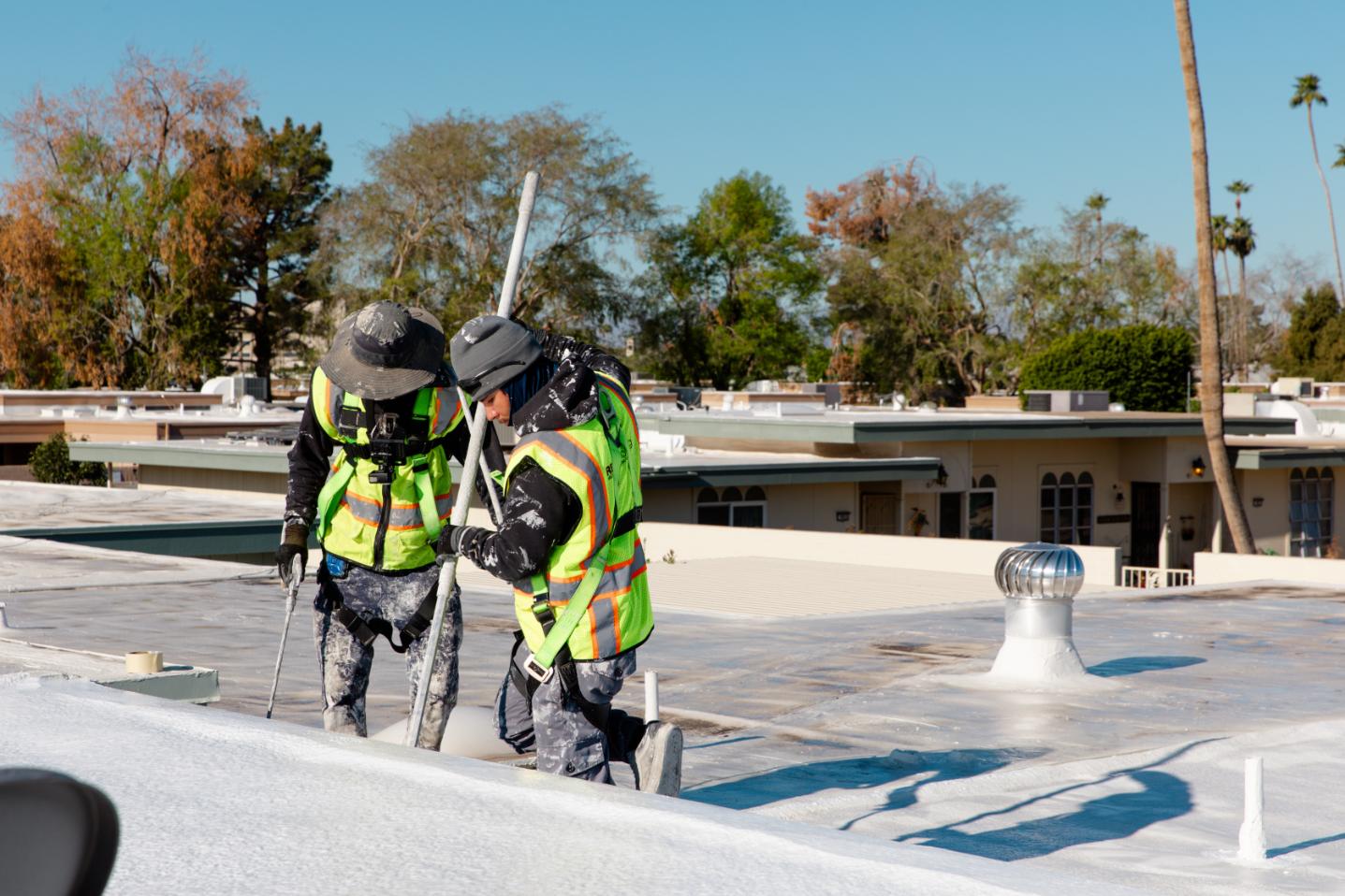 Workers Applying White Roof Coating