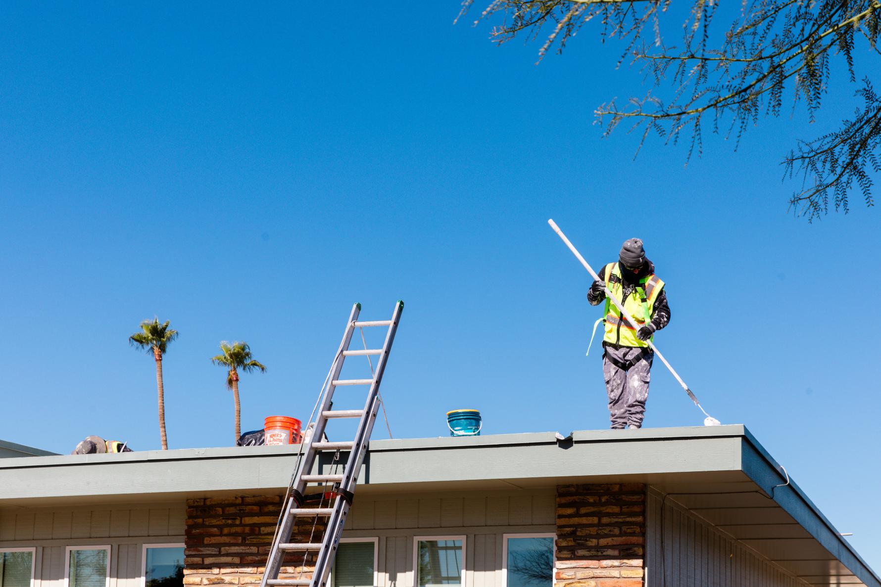 Man Applying White Coating to Roof