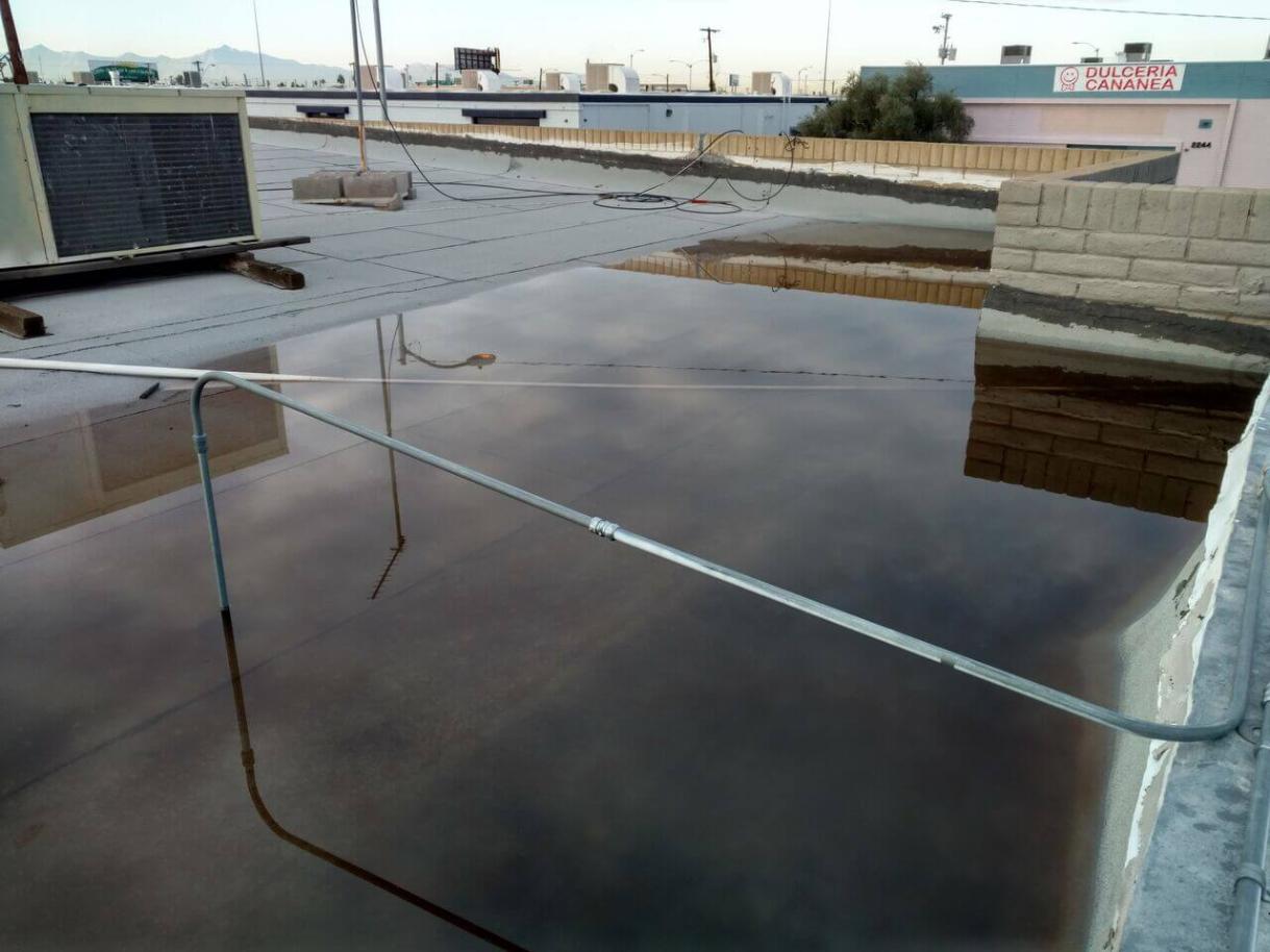 Damaged Flat Roof Flat roof with pooled water after rainfall
