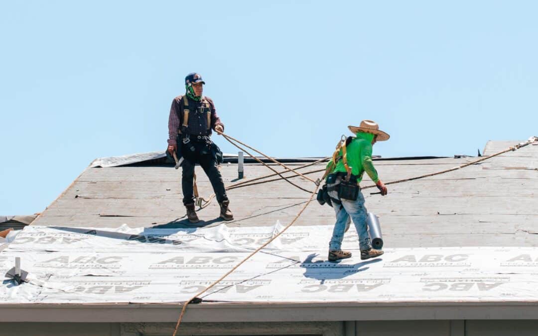 Two people working on roof during yearly phoenix winter roof preparation service