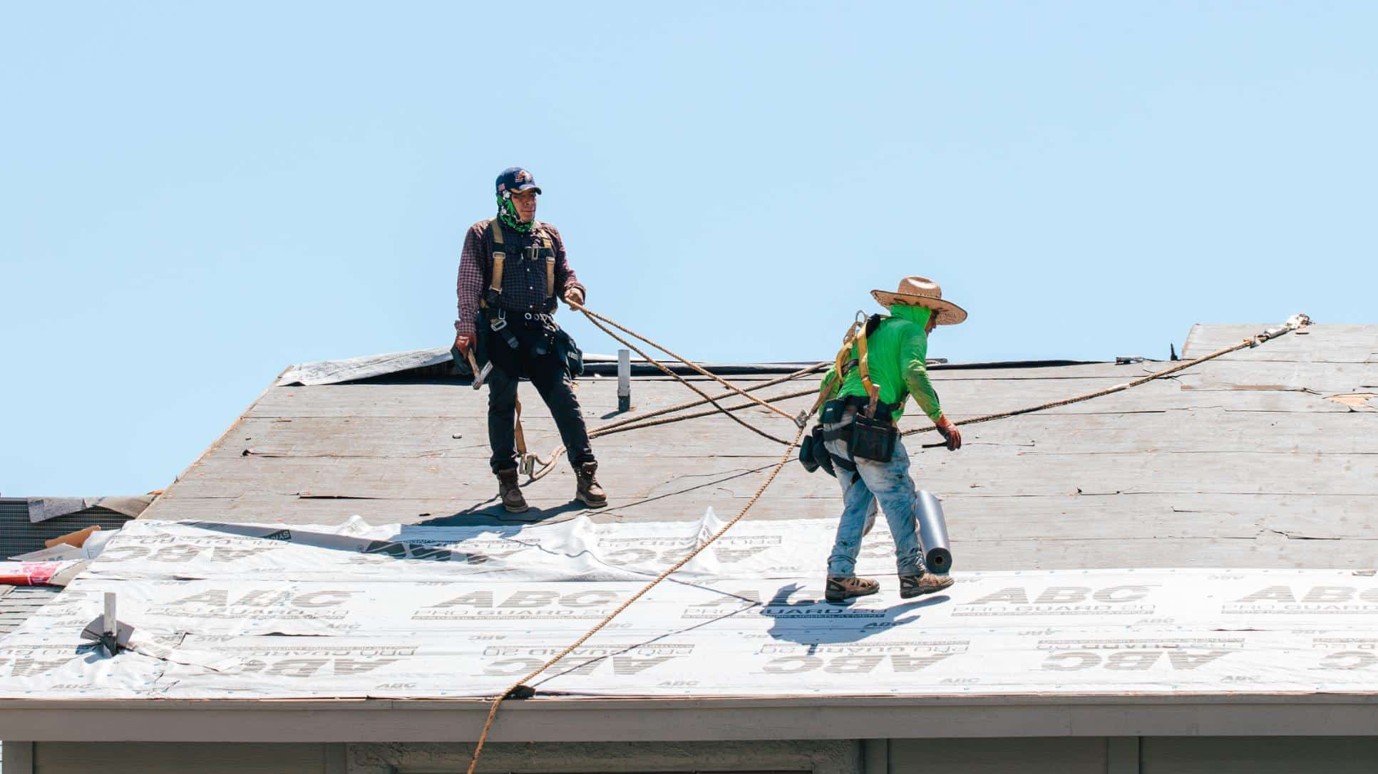 Two people working on roof during yearly phoenix winter roof preparation service