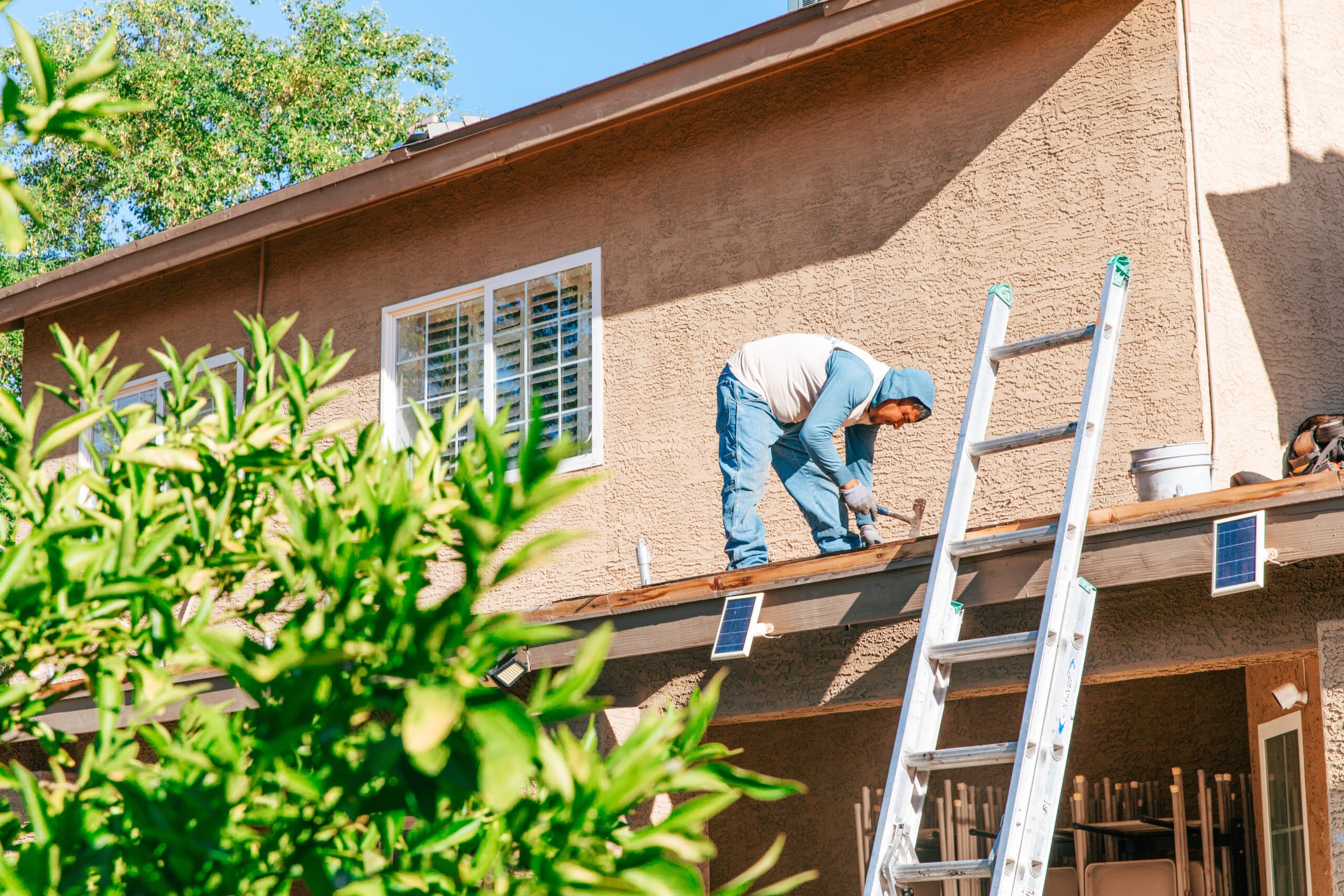 Man looking at gutters and roof for damage