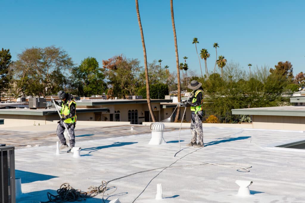 RENCO Roofing team applying coating to a roof to protect from winter rains