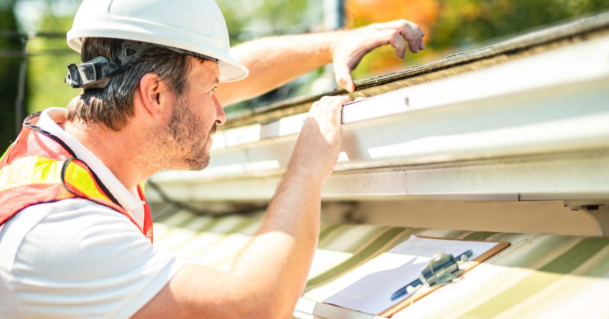 Roofer inspecting a roof in Peoria AZ